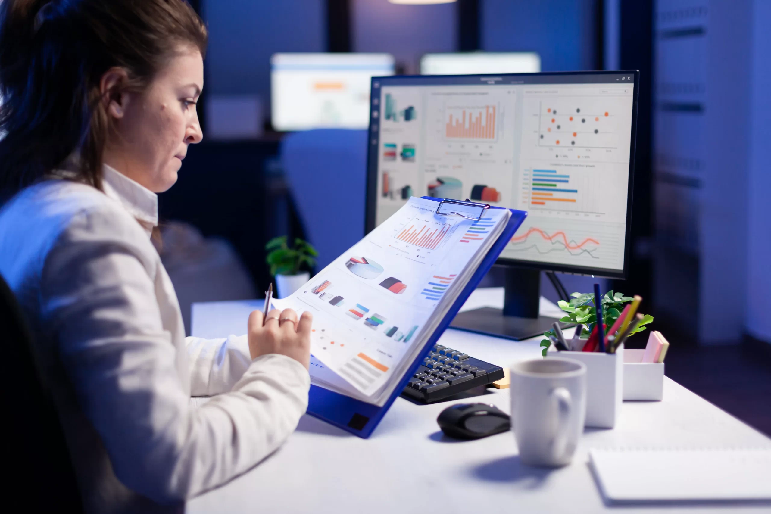 freelancer woman comparing graphics from clipboard with grafics from computer business office min scaled
