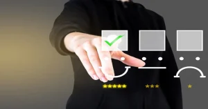 A person in a black hoodie selects a happy face icon with a green check mark from a satisfaction scale against a gray background